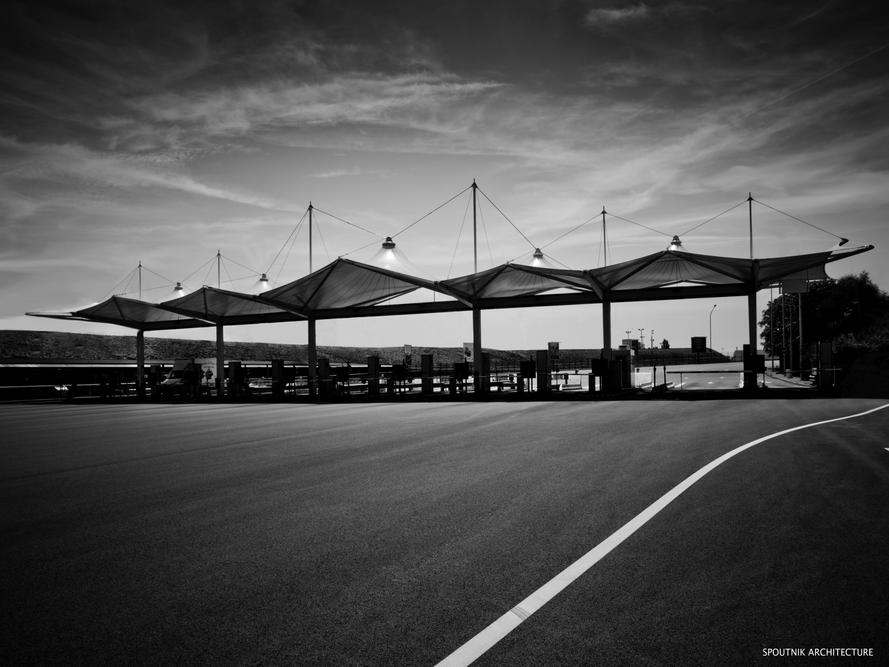 Péage d'autoroute couvert par ACS architecture métallo textile. La toile tenduedouble courbure Ferrari protège les usagers